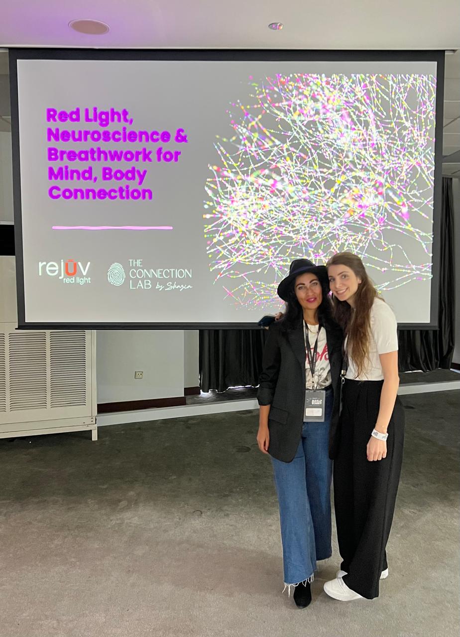 Shazia beside her talk slide on red light, neuroscience and breathwork